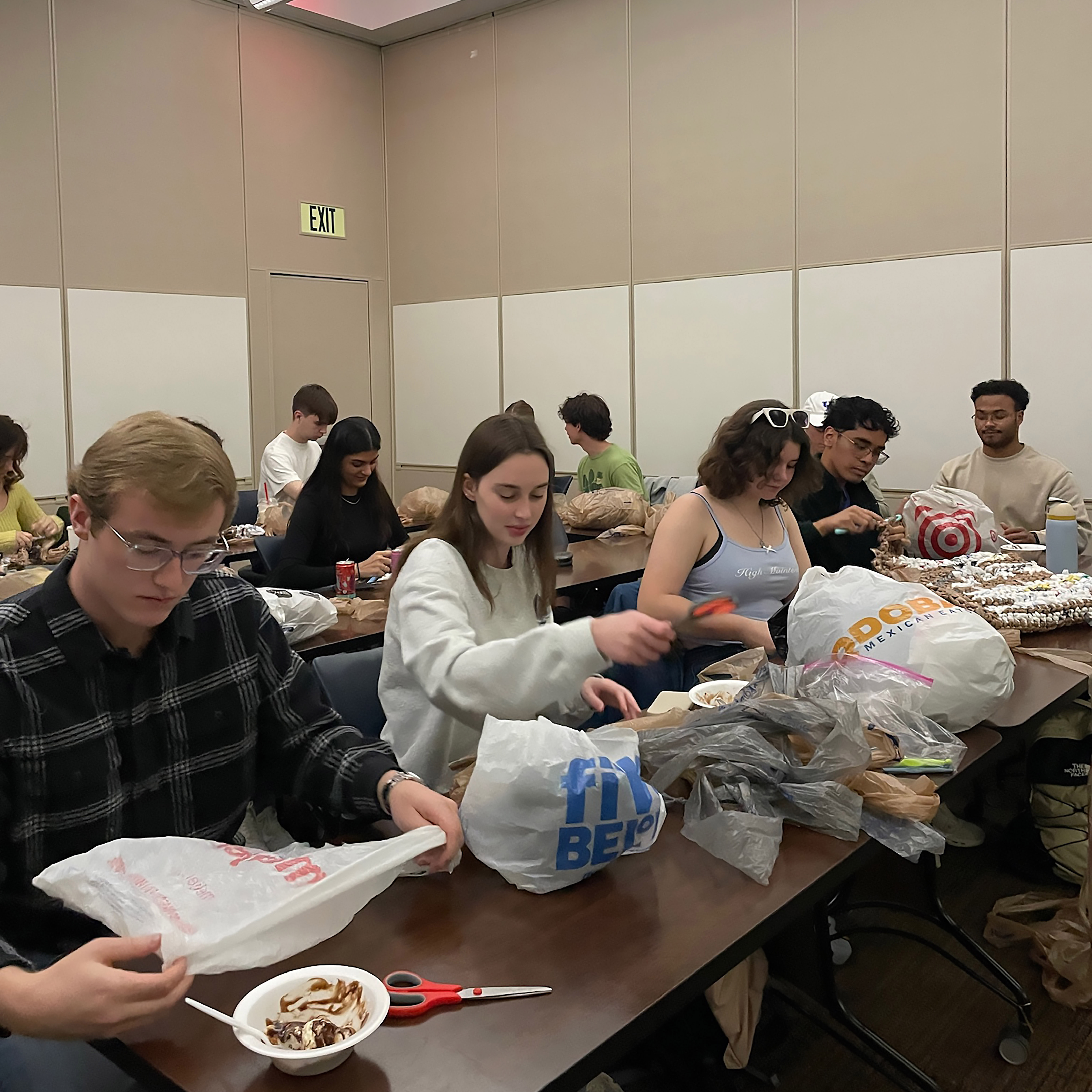 Club members cutting plastic bags into strips.