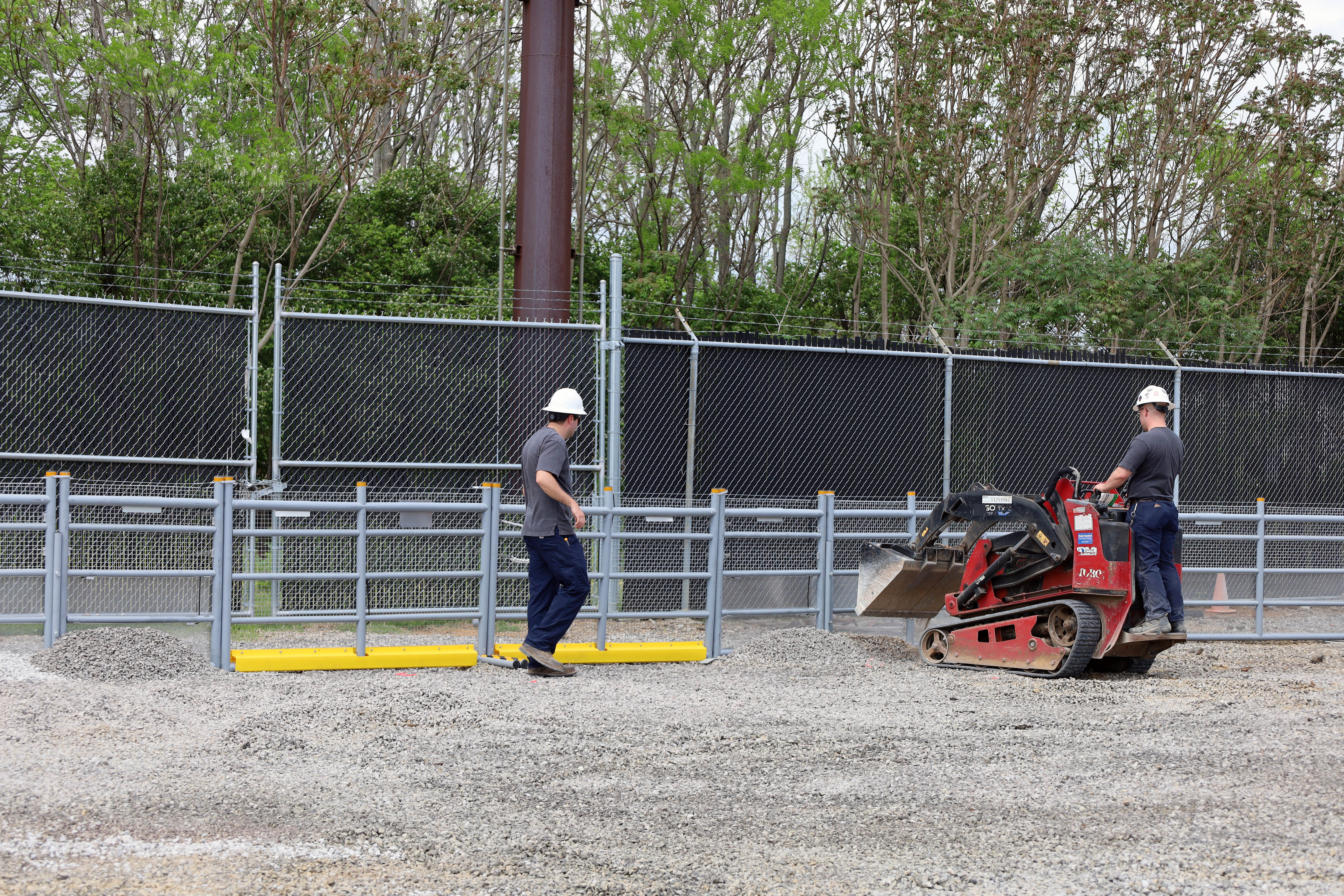 Facilities team members install fence 