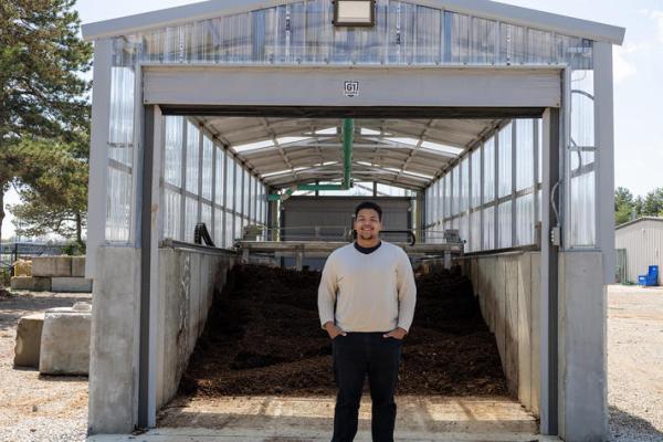 Jacob Hampton, a student, standing outside the composting system.