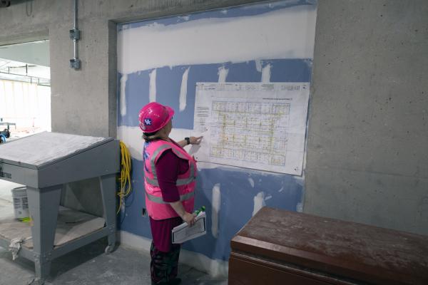 One woman looking at construction plans at renovation site
