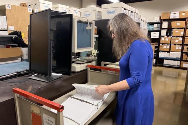 Facilties Information Services employee looking at archive documents