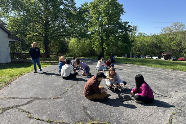 Students outside making rafts from materials found in nature
