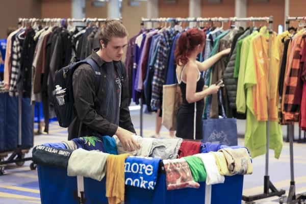Students looking at clothes at the Thrift Shop Pop Up