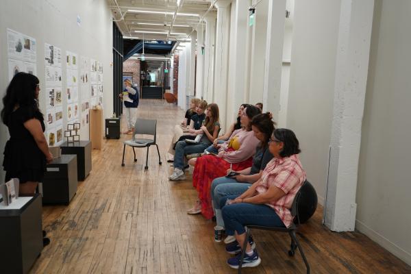 People sitting in hallway on campus for a design review for Save our Seeds