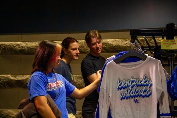 Students look at clothing on a rack