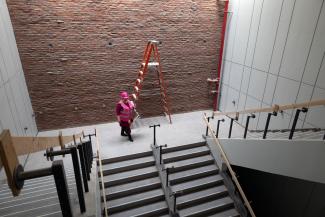 One woman going down stairs at the White Hall Classroom Building renovation site
