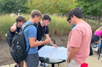 Students planning for the pollinator garden outside on campus.