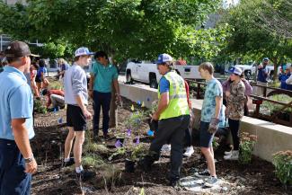 UK Grounds employees assist students in planting the pollinator garden