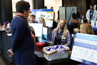 A person talking with a exhibitor at a table