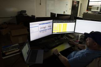 Controls Engineering team member working at three computer screens