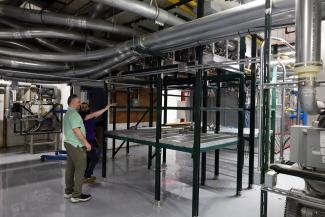 Two men looking at pneumatic tube system