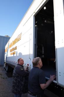 Two people look inside the rental deaerator tank which sits inside a full size trailer
