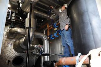 A person turns a dial on the rental deaerator tank