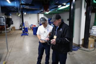 Facilities maintenance technicians looking at iPad and discussing a part that needs ordered