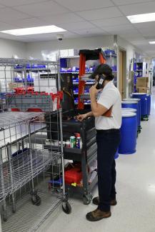 A facilities maintenance supervisor on a cell phone standing by a tool box