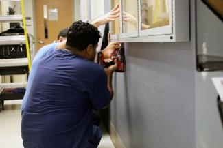 Maintenance technicians install new display cases on the wall