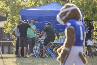 Photo of people and University of Kentucky mascot near booths outside