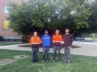 Arboriculture team members posed for a photo in front of a tree