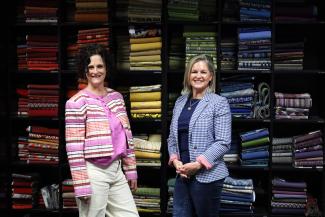 Interior designers in front of shelf of fabric samples