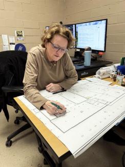 Facilities Information Services employee looks at a construction drawing