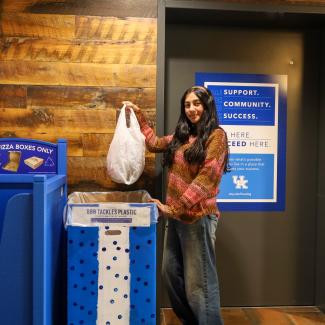 UK student disposing of plastic bags in the BBN Tackles Plastic collection bin.