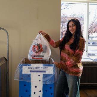 UK Student adding plastic bags into the collection bin.