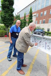 man signing construction beam