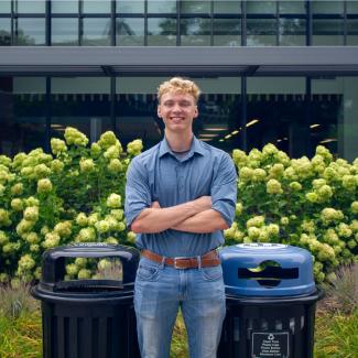 Henry Walke in front of a landfill and recycling bin.