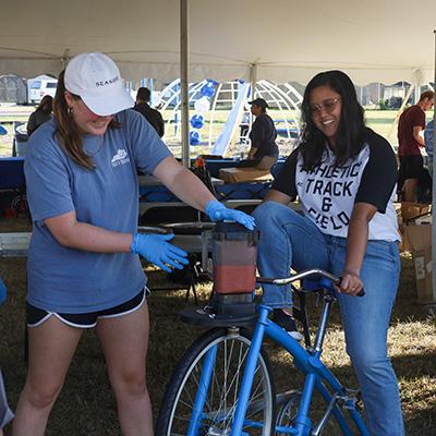 UK Student is making a smoothie while using a smoothie bicycle.