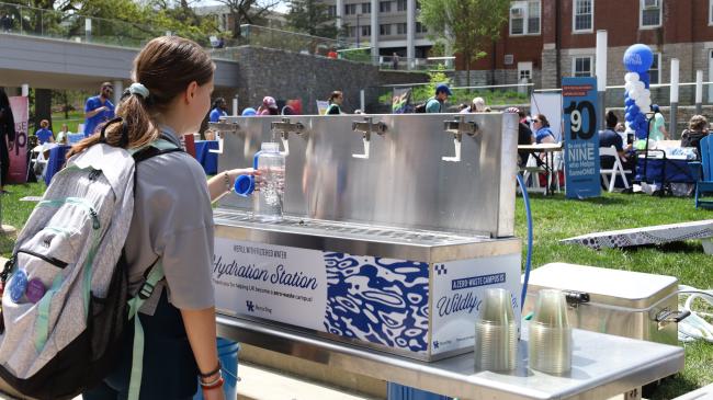 A student filling a reusable water bottle at a hydration station