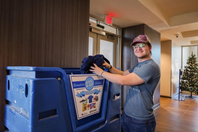 An image of clothing being added to a Give & Go container