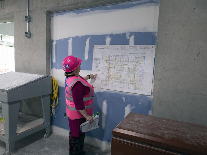 One woman looking at construction plans at renovation site