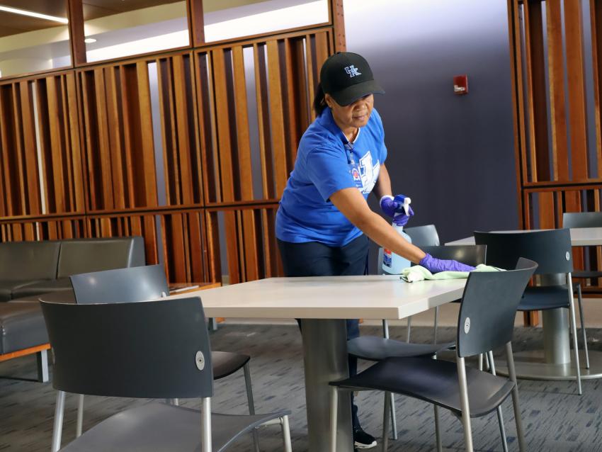  A custodial team member cleans a table
