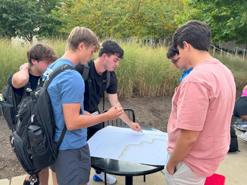 Students planning for the pollinator garden outside on campus.