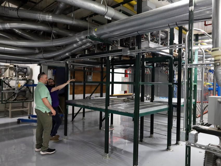 Controls Engineering team members looking at pneumatic tube system