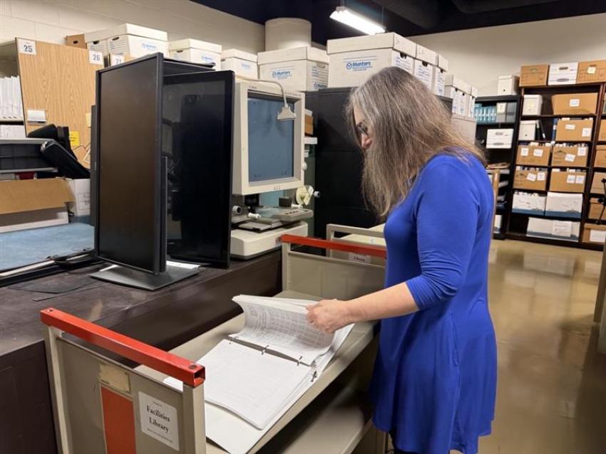 Facilties Information Services employee looking at archive documents