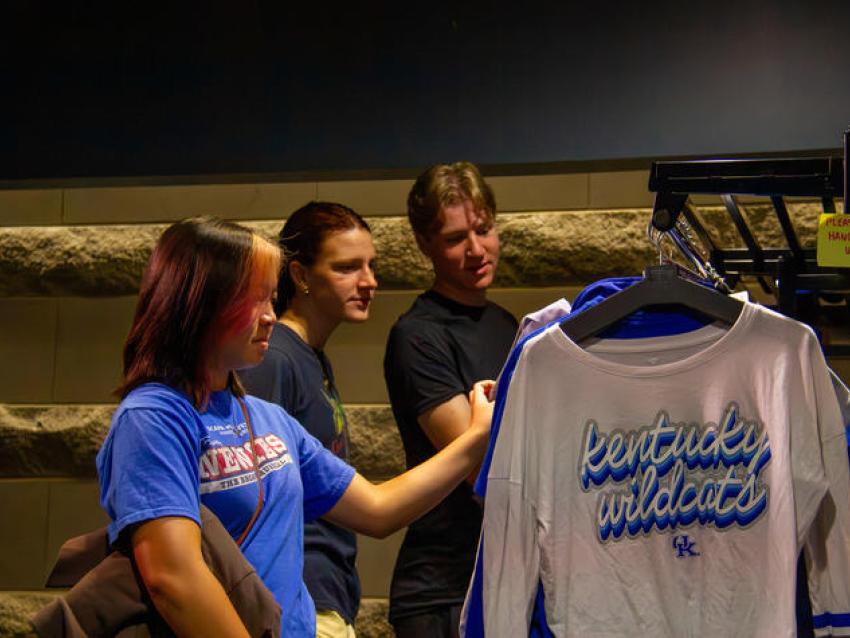 Students look at clothing on a rack