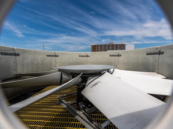 An image of a cooling tower fan with William T. Young Library in the background 